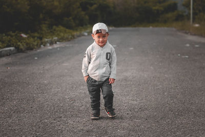 Portrait of young man standing on road