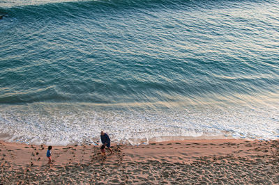 High angle view of people walking on beach