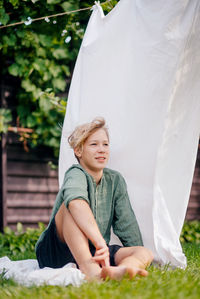 Portrait of young woman sitting on field