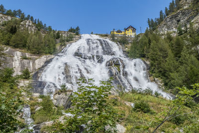 Scenic view of waterfall against sky