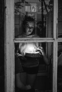 Portrait of young woman holding birthday cake