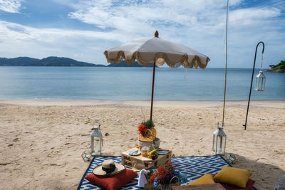 Luxury beach picnic set with snack, fruit, champagne, decorated flowers in hotel resort, phuket