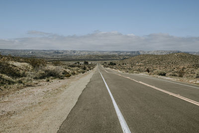 Lonely road with us mexico border wall in distance near jacumba, ca