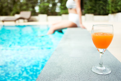 Glass of drinking water in swimming pool