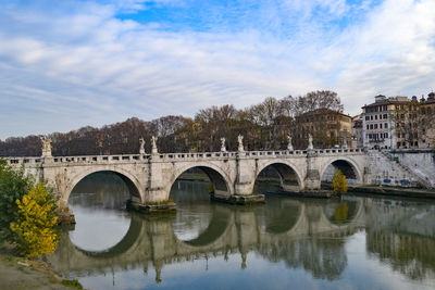 Arch bridge over river against sky