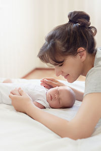 Mother with baby lying on bed