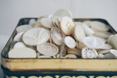 Close-up of white buttons in old metallic box