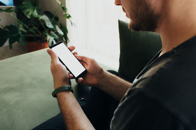 Midsection of man using mobile phone