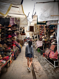 Rear view of woman walking at market stall