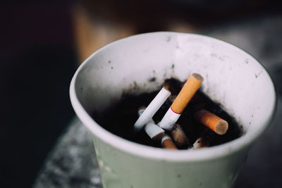 Close-up of cigarette smoking in container