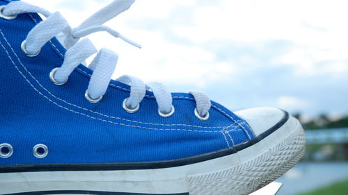 Close-up of shoe on blue water