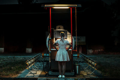 Woman sitting on seat in illuminated at night