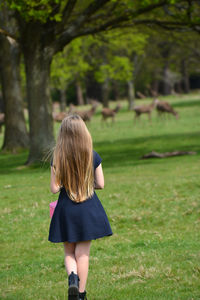 Rear view of girl standing on field