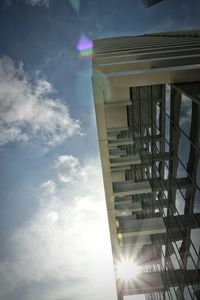 Low angle view of sun shining through clouds