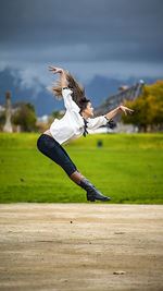 Full length of woman exercising on field