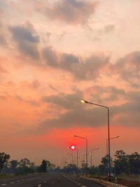 Cars on street against orange sky