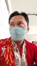 Portrait of man standing against red wall