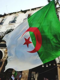 Low angle view of flag against buildings in city