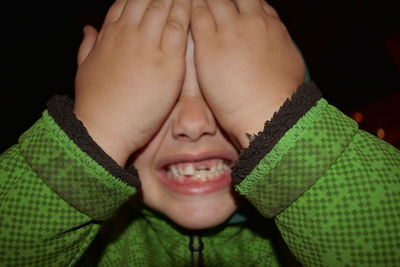 Close-up of boy with hands covering eyes