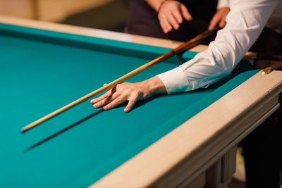 Midsection of man playing pool