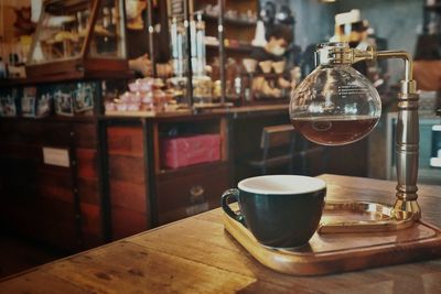 Coffee cup on wood table in old cafe