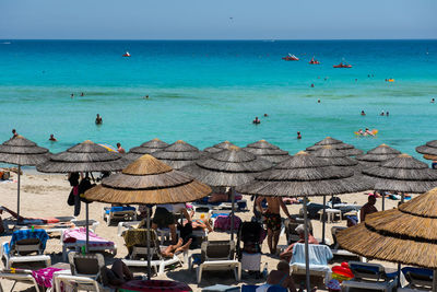 People at beach against sky