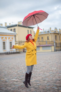 Woman with umbrella standing in rain