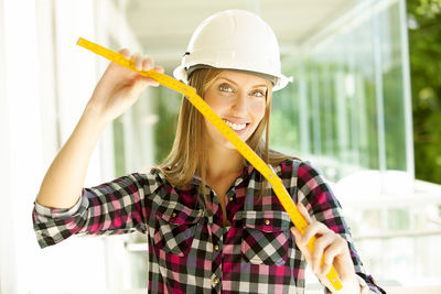 Portrait of smiling female architect holding tape measure