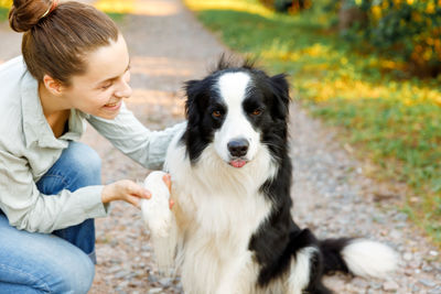 Woman petting dog snout at park