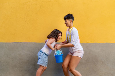 Full length of a boy holding yellow wall