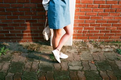 Low section of woman standing on footpath