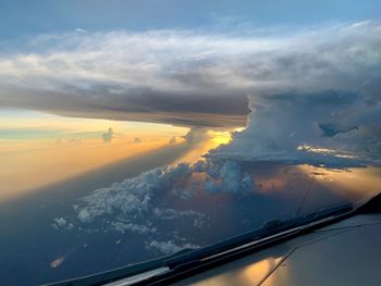 Airplane wing against sky during sunset