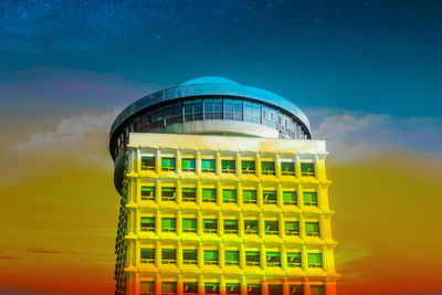 Low angle view of yellow building against sky at sunset