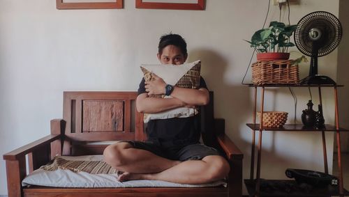 Young man sitting on chair at home