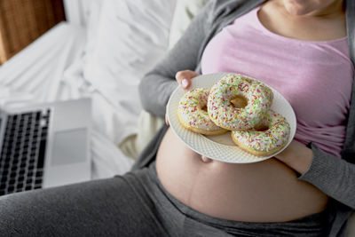 Midsection of woman holding cake