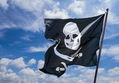 Low angle view of flag against blue sky