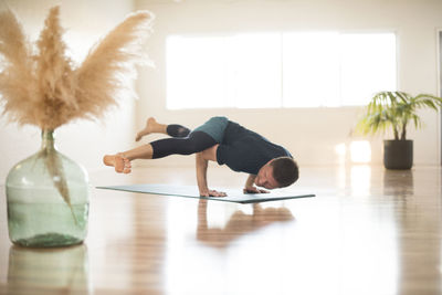 A guy in hurdlers pose during yoga.