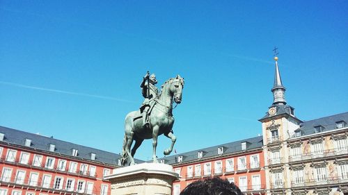 Low angle view of statue against blue sky