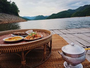 High angle view of food on table at lake against mountains