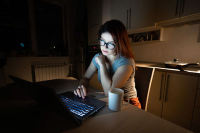 Woman working late on laptop at home