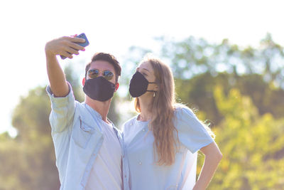 Portrait of young woman wearing sunglasses standing outdoors