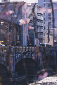 Bridge over river by buildings in city