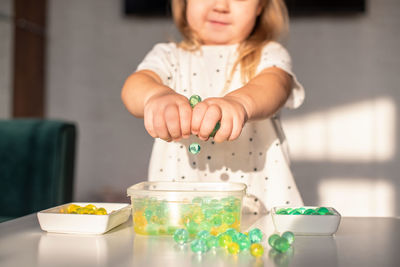 Midsection of girl playing with hydro gel