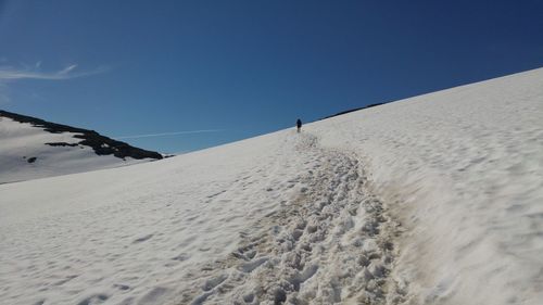 Low angle view of sand dune against clear blue sky