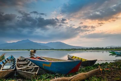 Fishing boats moored on beach against sky