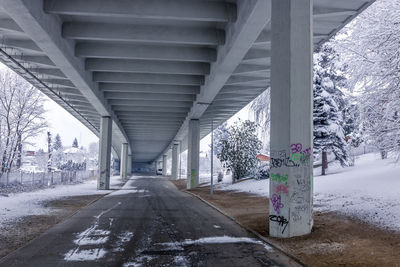 Empty road along snow covered bridge