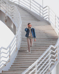 Full length of young woman standing on staircase