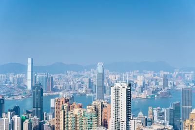 Modern buildings in city against blue sky