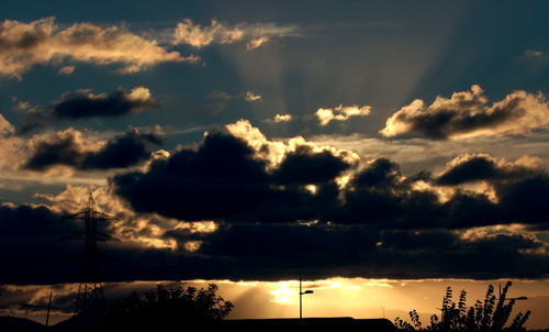 Low angle view of silhouette trees against cloudy sky