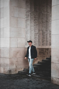 Full length of man standing against wall